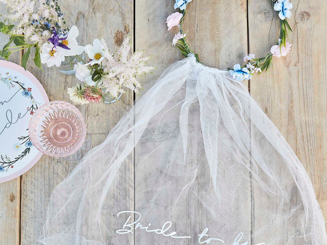 Pasirūpinkite, o skraistės ilgis - 30 cm., kurio apimtis - 60 cm, naudodama šią gėlių karūna ir permatoma skraiste su užrašu „Bride to Be“ (Būsima nuotaka). Stilingas galvos apdangalas neabejotinai atrodys nuostabiai kartu su kitais jūsų mergvakario aksesuarais. Vainikas yra sudaryta iš pievų margučių ir rožinių rožių gėlių. Pakuotėje yra 1x vainikas, kad gražioji būsimoji nuotaka stilingai atšvęstų savo mergvakario šventę