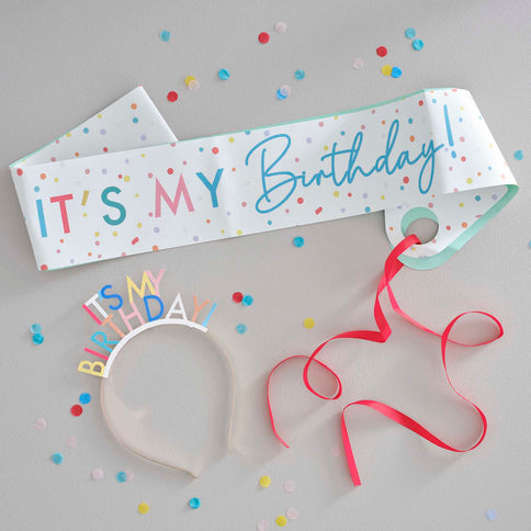Gimtadienio diena turi būti linksma ir džiugi! Šią spalvingą šventinę juostą ir galvos lankelį  užrašu "It's My Birthday" būtina turėti per kiekvieną gimtadienio šventę. Padovanokite gimtadienio kaltininkui arba nusipirkite patys! Šiuos gimtadienio aksesuarus derinkite su spalvingomis dekoracijomis iš mūsų vakarėlių ar gimtadieninių kolekcijų. Pakuotėje yra 1x gimtadienio galvos lankelis ir 1 x reguliuojama 155 cm ilgio juosta.