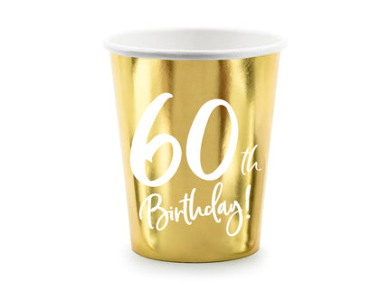 Metalinės aukso spalvos popieriniai puodeliai su baltu užrašu "60th Birthday!", talpinantys iki apie 220 ml.